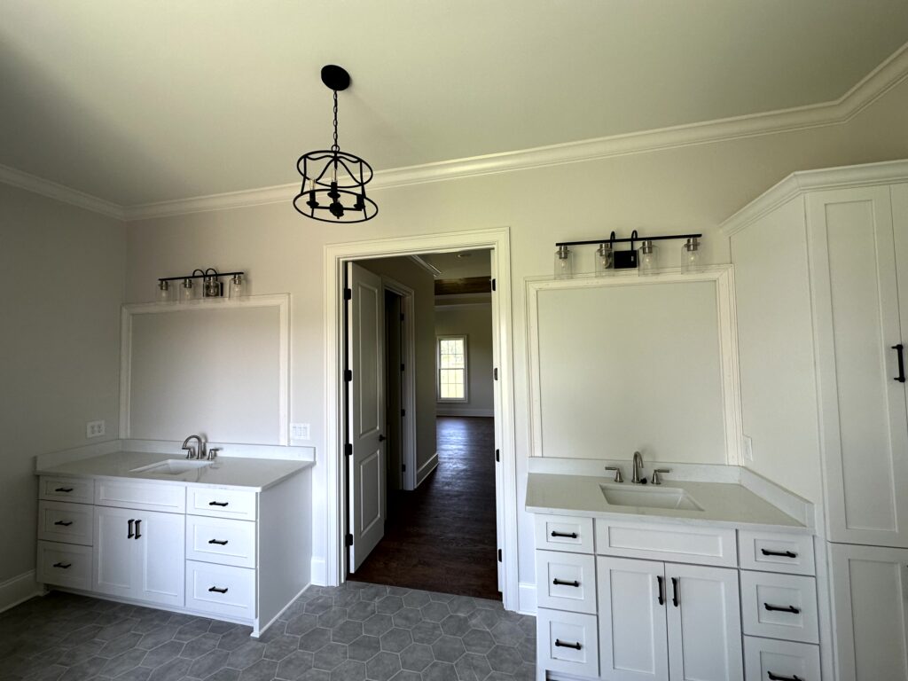 Interior of a bathroom with sinks in the left and right side of the door.