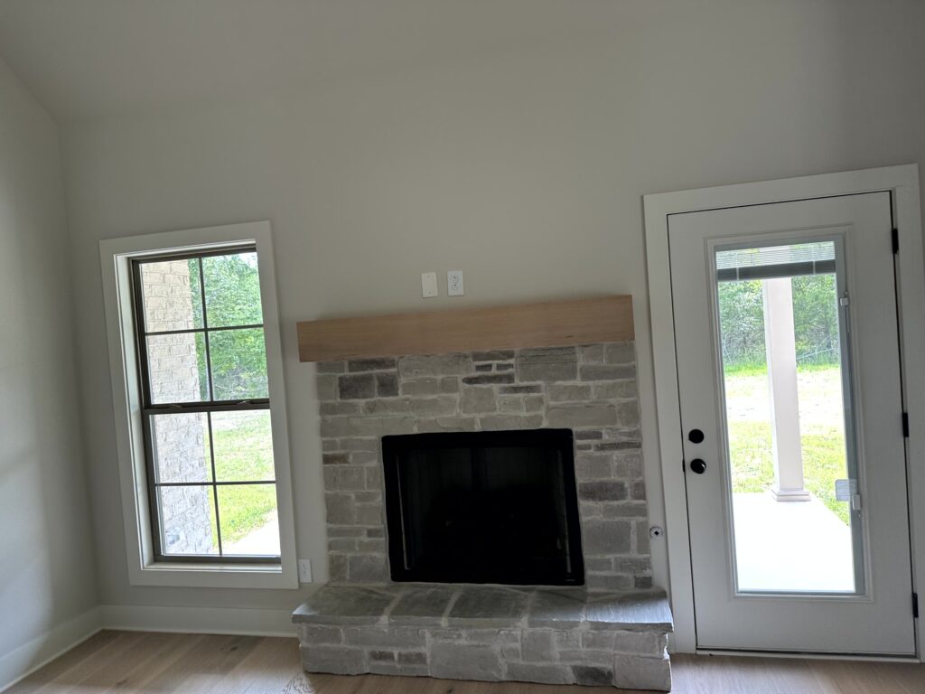 House interior - White walls, fire place, vertical window in the left, semi-glass door in the right