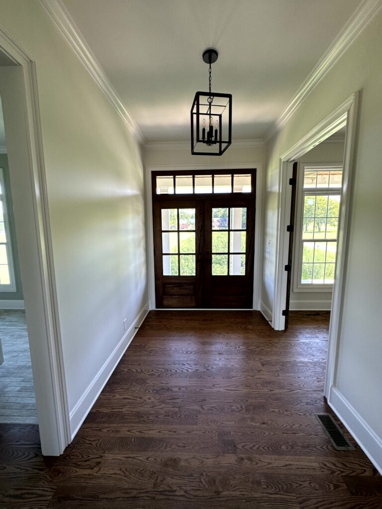 Newly painted hallway with white walls and a door at the end